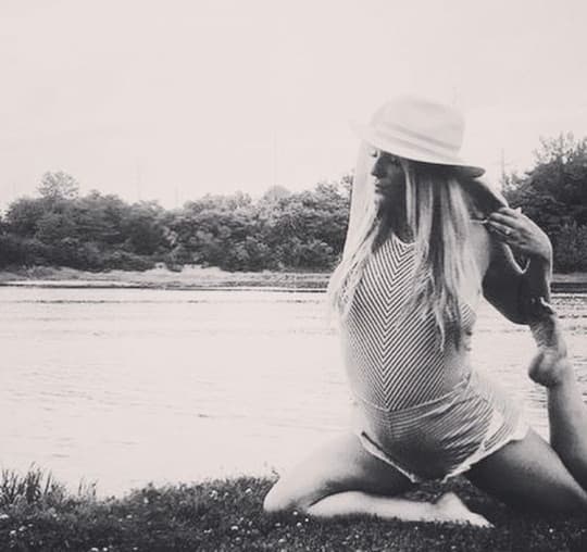Alexandra (Bosee) Jeske in a seated yoga pose by the water