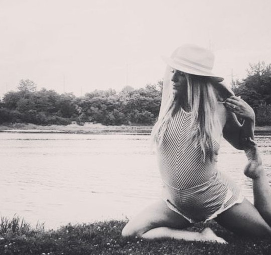 Alexandra (Bosee) Jeske in a seated yoga pose by the water